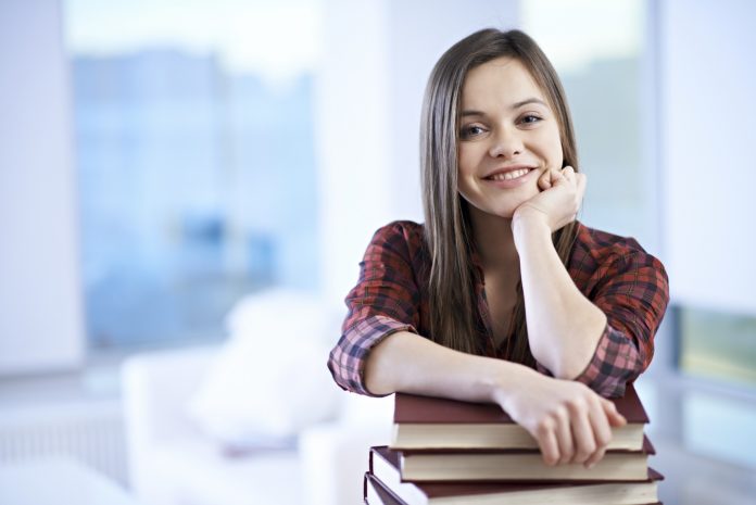 Portrait of smiling female student with books