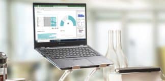 Zu sehen ist ein Notebook, dass auf einem erhöhten Standfuß auf einem Schreibtisch steht. Der Standfuß ermöglicht einen komfortablen Blick auf das Notebook für den Nutzer.