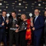 Es sind glückliche MEnschen zu sehen, die sich über einen Preis freuen.