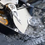 Offene Festplatte mit den Magnetscheiben in Wasser getaucht um einen Wasserschaden zu simulieren