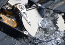 Offene Festplatte mit den Magnetscheiben in Wasser getaucht um einen Wasserschaden zu simulieren