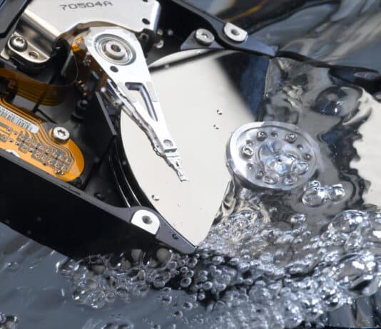 Offene Festplatte mit den Magnetscheiben in Wasser getaucht um einen Wasserschaden zu simulieren
