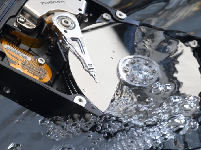 Offene Festplatte mit den Magnetscheiben in Wasser getaucht um einen Wasserschaden zu simulieren
